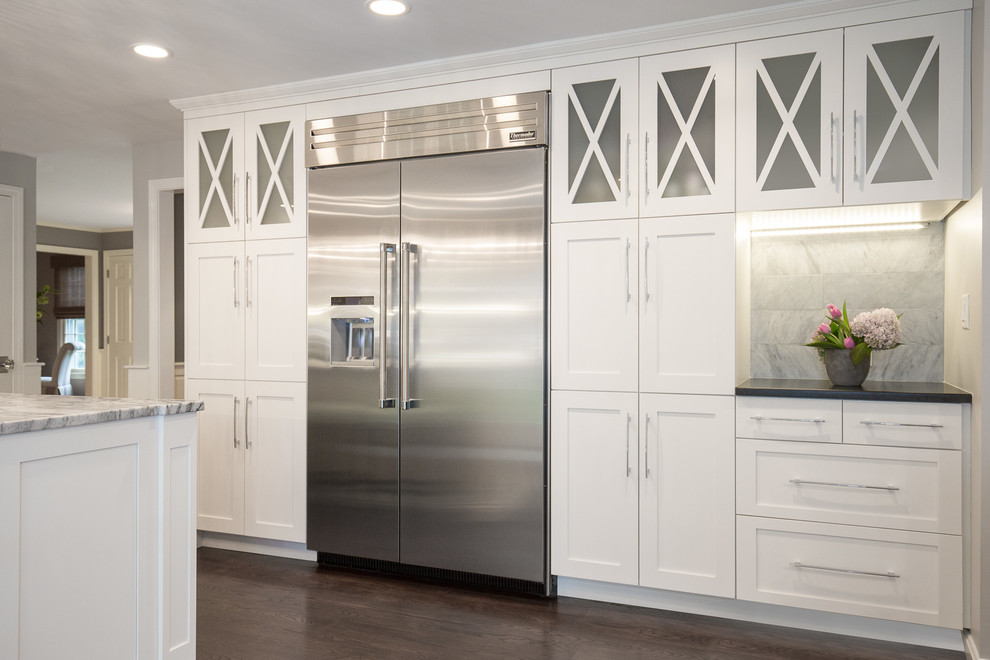 Mid-sized transitional l-shaped dark wood floor open concept kitchen photo in Boston with an undermount sink, shaker cabinets, white cabinets, marble countertops, gray backsplash, stone tile backsplash, stainless steel appliances and an island