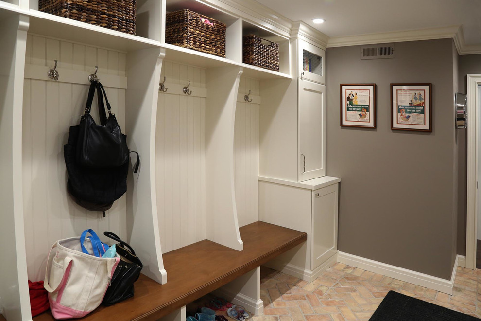 Design ideas for a mid-sized traditional mudroom in Chicago with grey walls and brick floors.