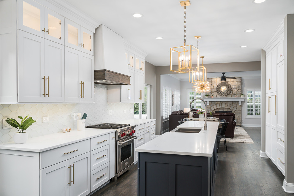 Inspiration for a mid-sized transitional galley open plan kitchen in Chicago with white cabinets, quartz benchtops, white splashback, stainless steel appliances, dark hardwood floors, with island, brown floor, white benchtop, a farmhouse sink, shaker cabinets and glass tile splashback.