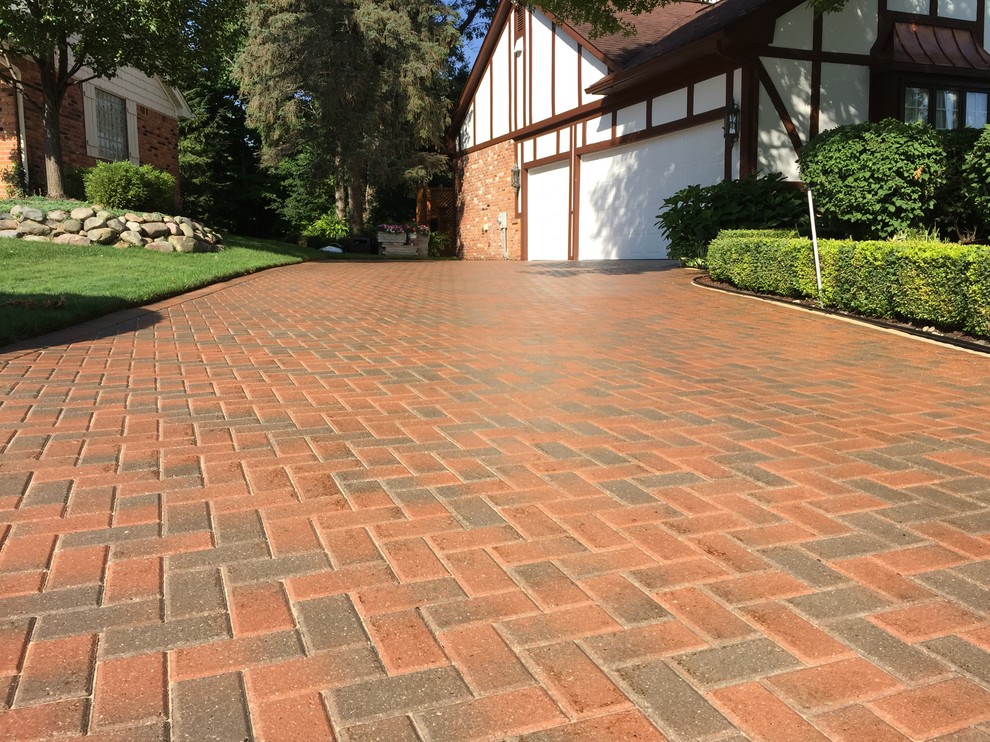 Design ideas for a mid-sized front yard driveway in Detroit with brick pavers.