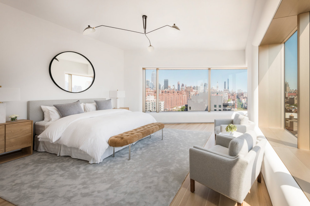 Inspiration for a modern bedroom in New York with white walls, light hardwood floors and beige floor.