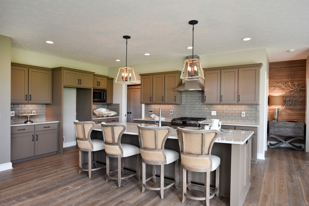 Eat-in kitchen - l-shaped medium tone wood floor eat-in kitchen idea with a double-bowl sink, recessed-panel cabinets, gray cabinets, gray backsplash, glass tile backsplash, stainless steel appliances, an island and multicolored countertops