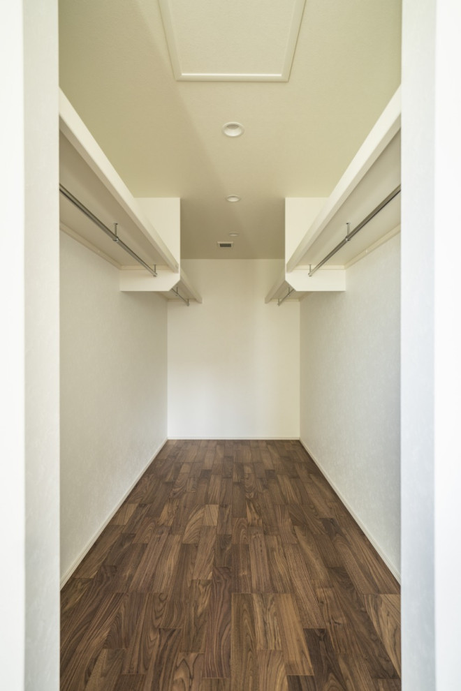 Modelo de armario vestidor unisex minimalista de tamaño medio con suelo de madera oscura, suelo marrón y papel pintado