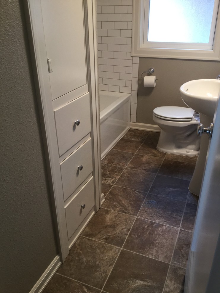 Inspiration for a small traditional 3/4 bathroom in Portland with flat-panel cabinets, white cabinets, an alcove tub, a shower/bathtub combo, a two-piece toilet, multi-coloured tile, subway tile, beige walls, slate floors and a pedestal sink.