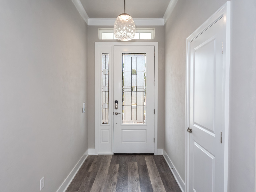 Design ideas for a foyer in Other with black walls, laminate floors, a single front door, a glass front door and multi-coloured floor.