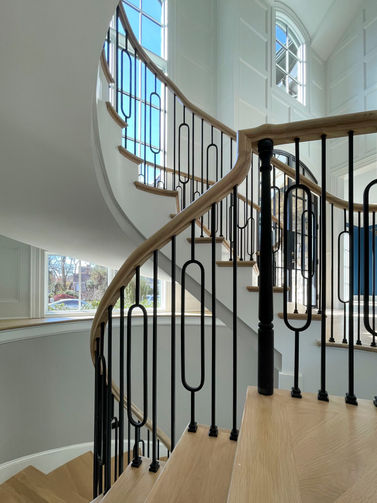 Inspiration for a huge transitional wooden curved mixed material railing and wainscoting staircase remodel in DC Metro with wooden risers