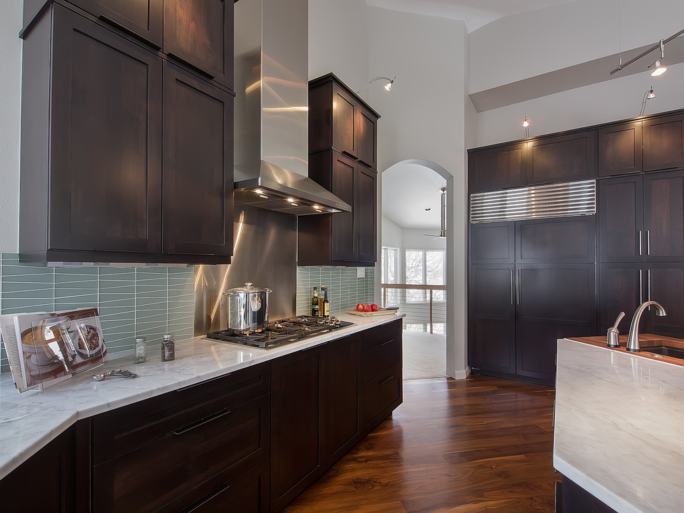 Photo of a contemporary kitchen in Denver with an undermount sink, shaker cabinets, dark wood cabinets, marble benchtops, blue splashback, glass tile splashback and stainless steel appliances.