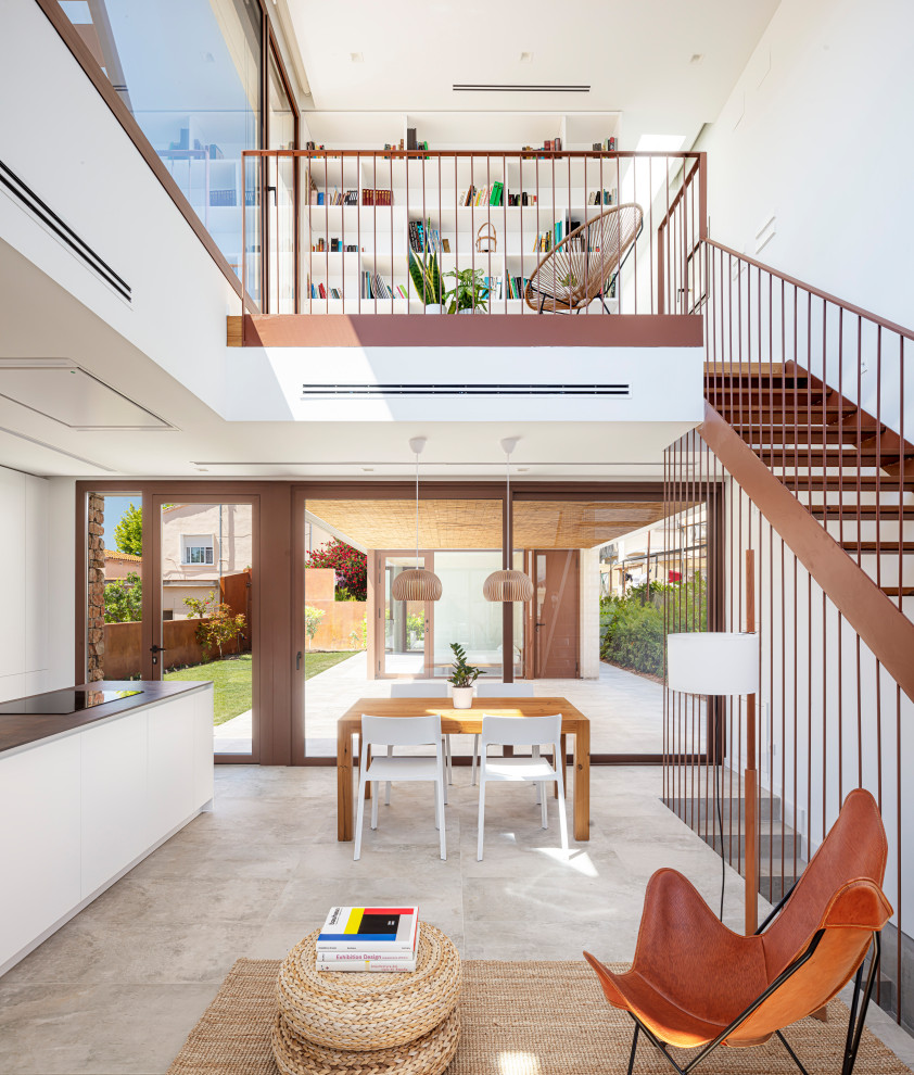 Mittelgroße Moderne Wohnküche mit weißer Wandfarbe, Porzellan-Bodenfliesen, Tunnelkamin, Kaminumrandung aus Metall und beigem Boden in Sonstige