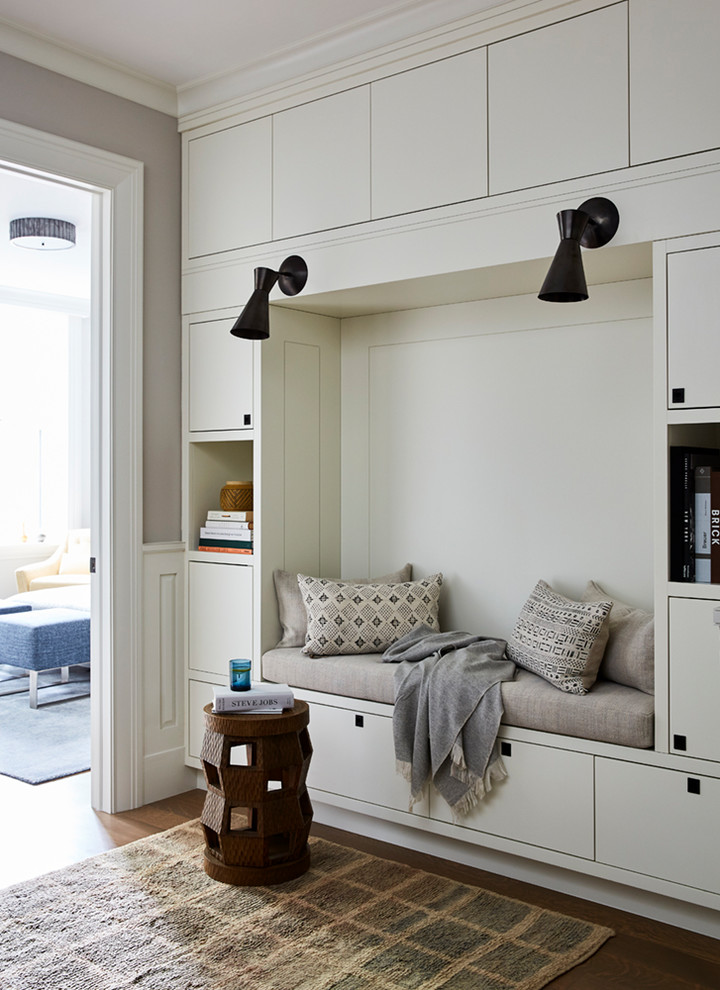 This is an example of a transitional bedroom in New York with white walls and medium hardwood floors.