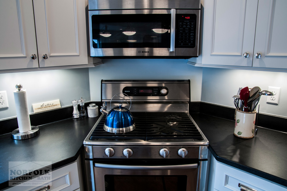 Example of a transitional l-shaped medium tone wood floor open concept kitchen design in Boston with a single-bowl sink, recessed-panel cabinets, white cabinets, granite countertops, stainless steel appliances and an island