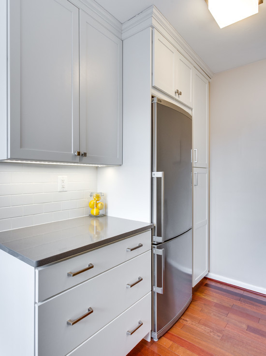 This is an example of a small traditional galley eat-in kitchen in DC Metro with a drop-in sink, recessed-panel cabinets, grey cabinets, granite benchtops, white splashback, ceramic splashback, stainless steel appliances, dark hardwood floors and no island.