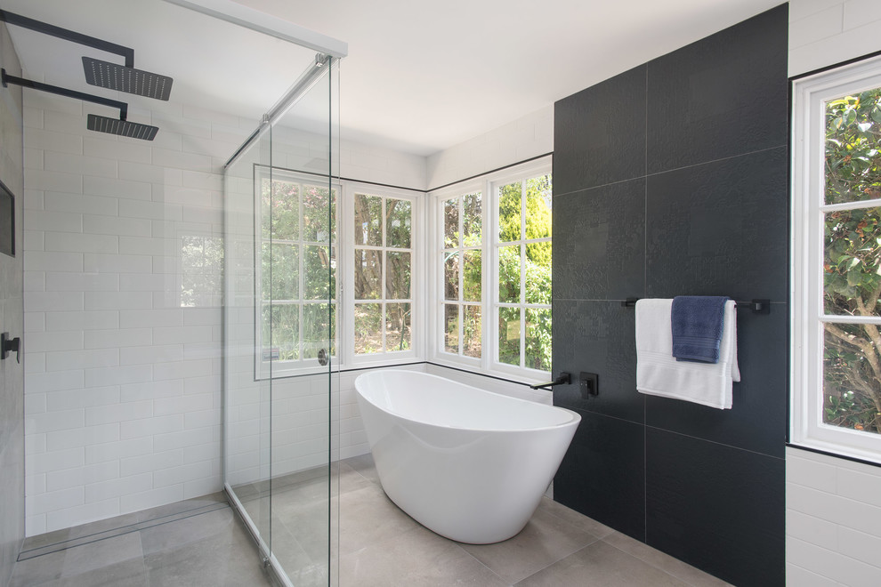 Mid-sized contemporary master bathroom in Other with recessed-panel cabinets, dark wood cabinets, a freestanding tub, a double shower, a one-piece toilet, black and white tile, porcelain tile, white walls, ceramic floors, a wall-mount sink, solid surface benchtops, grey floor, a hinged shower door and white benchtops.