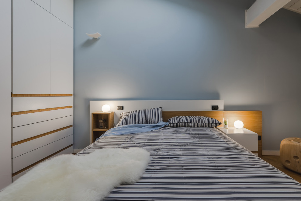 ミラノにある広い北欧スタイルのおしゃれな主寝室 (マルチカラーの壁、淡色無垢フローリング、ベージュの床、表し梁) のインテリア
