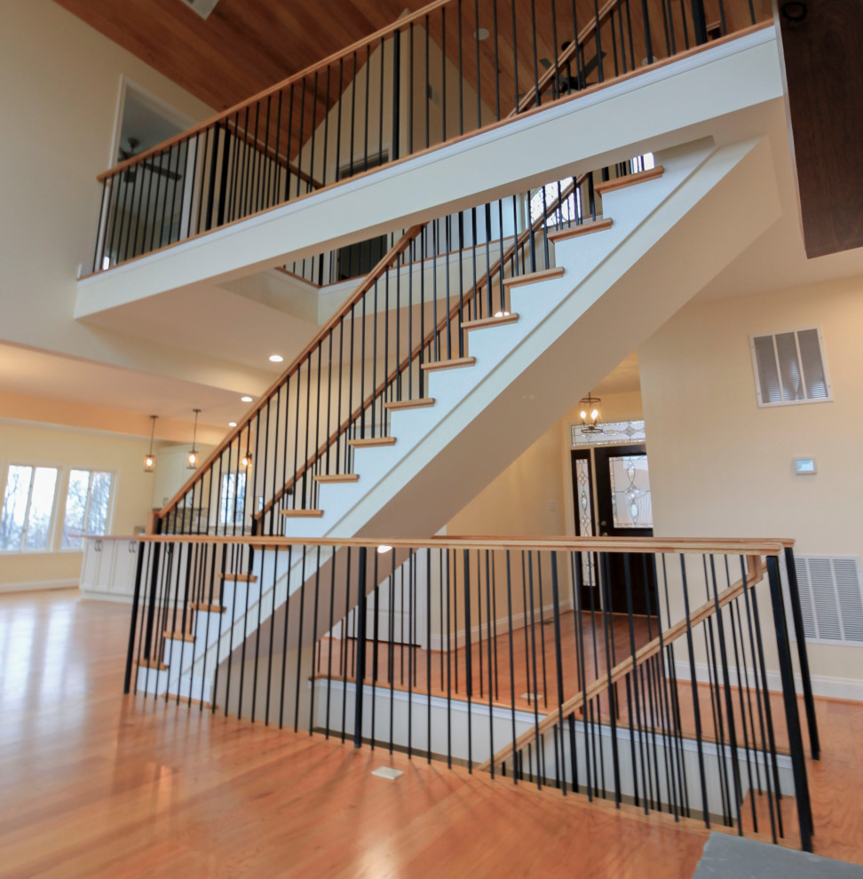 Design ideas for a large classic wood floating mixed railing staircase in DC Metro with wood risers and tongue and groove walls.