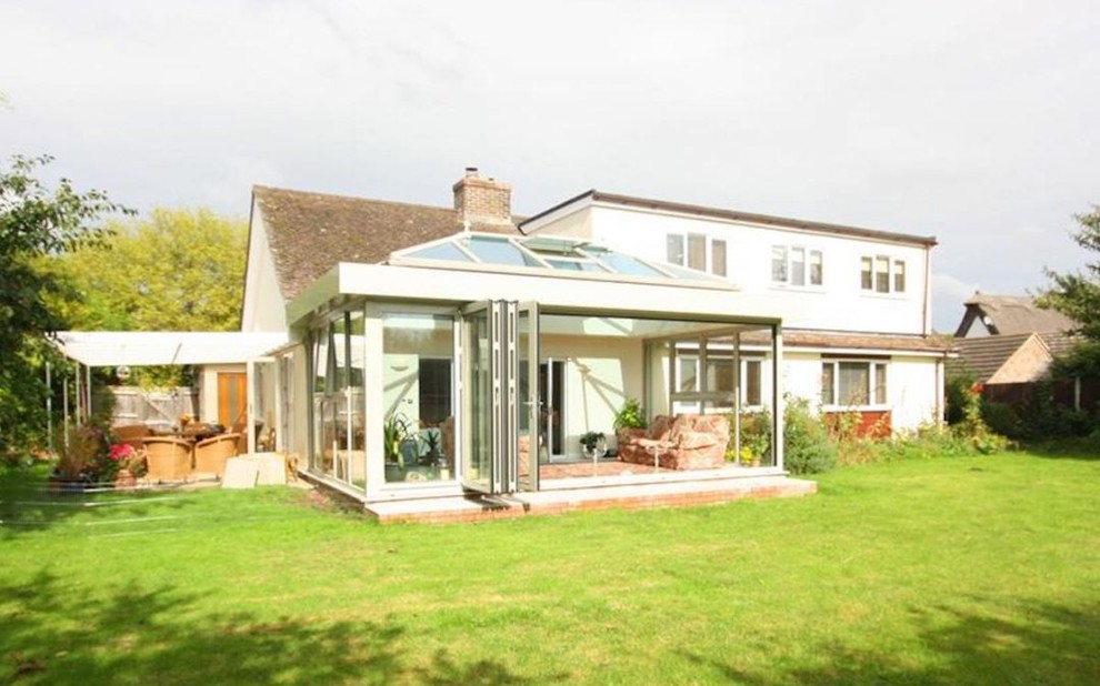 Design ideas for a large modern sunroom in Cambridgeshire with ceramic floors, a glass ceiling and beige floor.