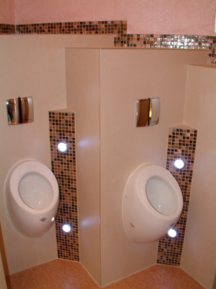Inspiration för ett stort vintage beige beige toalett, med en vägghängd toalettstol, brun kakel, glaskakel, beige väggar, linoleumgolv, ett fristående handfat, bänkskiva i glas och orange golv
