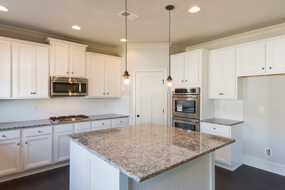 Inspiration for a large transitional u-shaped dark wood floor and brown floor eat-in kitchen remodel with an undermount sink, recessed-panel cabinets, white cabinets, granite countertops, white backsplash, subway tile backsplash, stainless steel appliances and an island