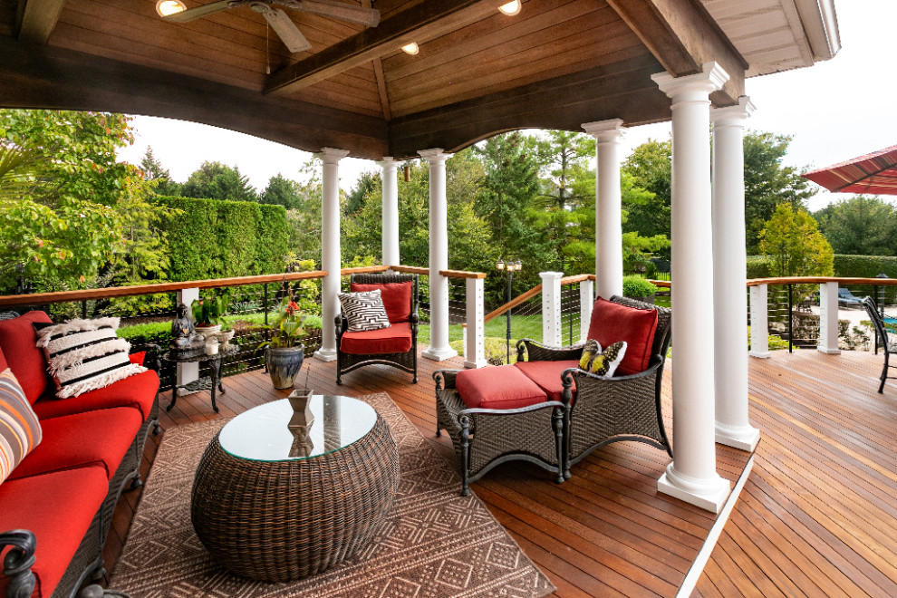 Large transitional backyard deck photo with a roof extension