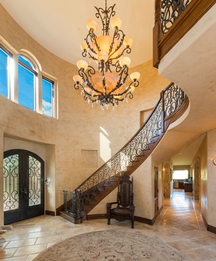 This is an example of an expansive mediterranean wood curved staircase in Los Angeles with wood risers.