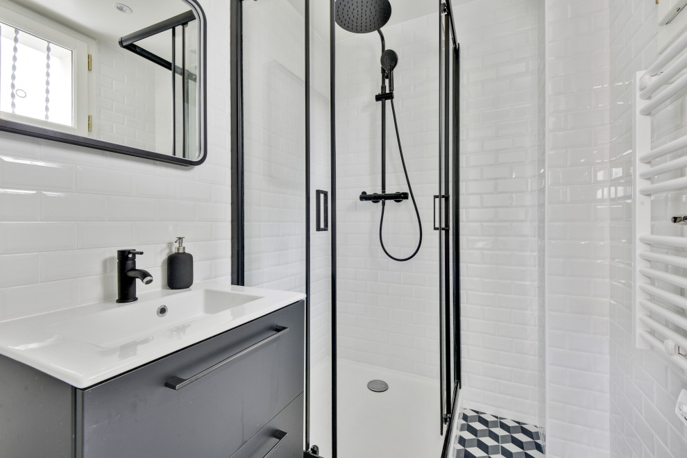 Пример оригинального дизайна: маленькая детская ванная комната в стиле лофт с черными фасадами, угловым душем, белой плиткой, плиткой кабанчик, белыми стенами, полом из цементной плитки, раковиной с пьедесталом, столешницей из искусственного камня, серым полом, душем с раздвижными дверями, белой столешницей, тумбой под одну раковину и подвесной тумбой для на участке и в саду