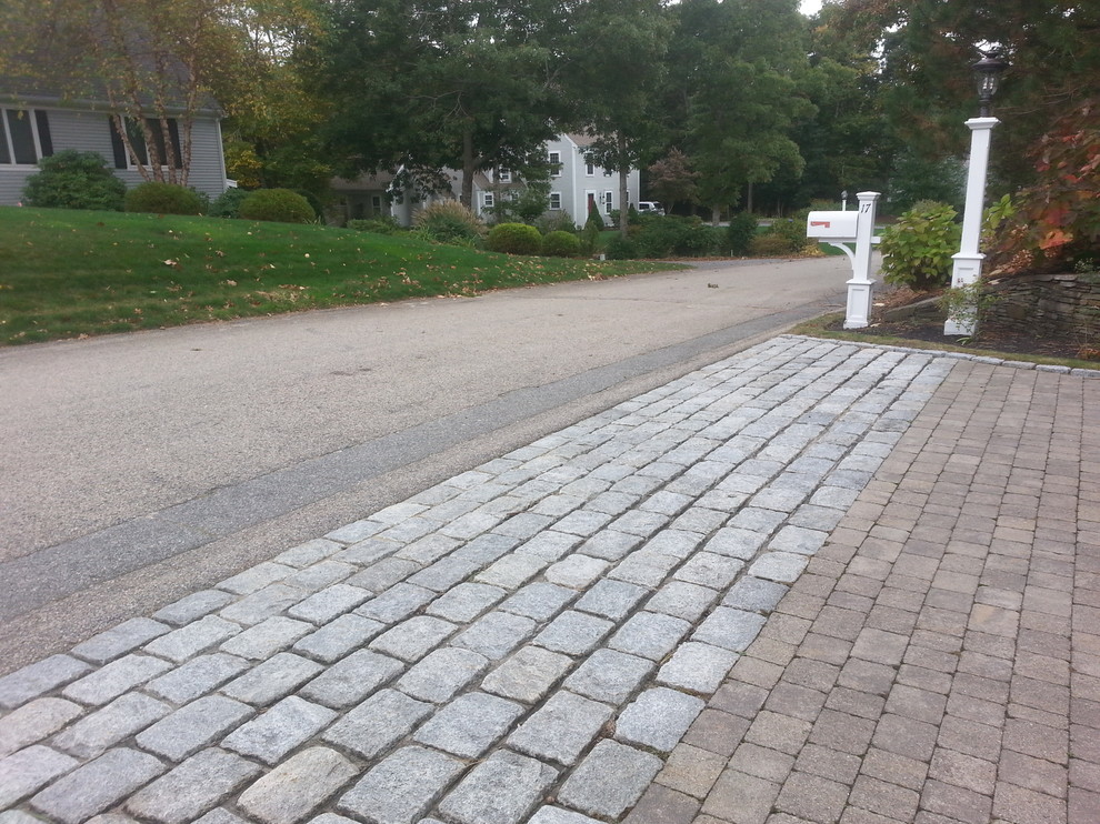 This is an example of a mid-sized traditional front yard driveway in Boston with brick pavers.