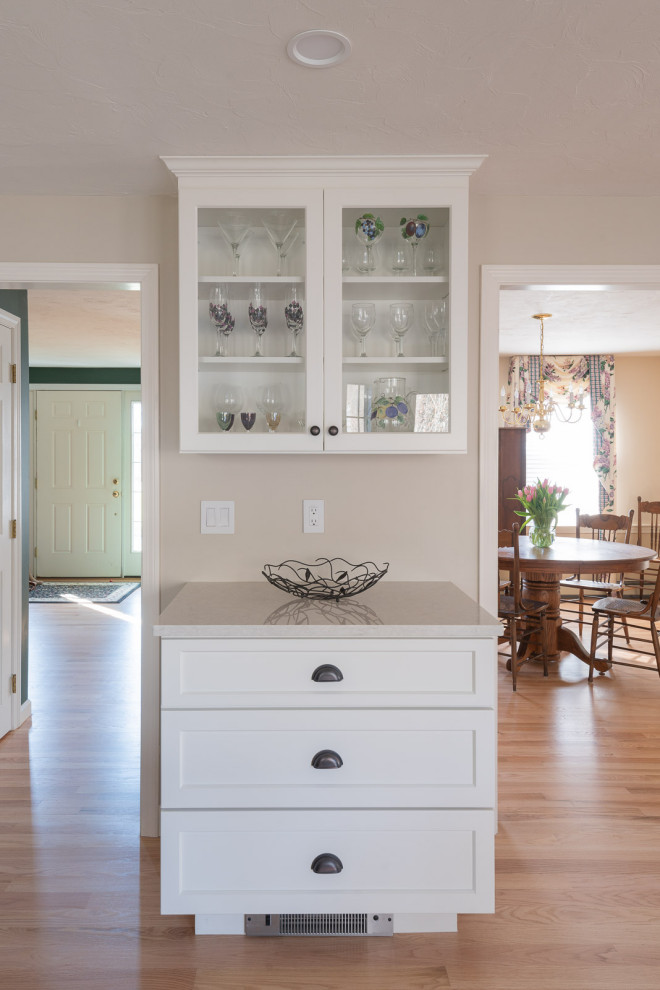 Example of a large transitional galley light wood floor and brown floor eat-in kitchen design in Boston with an undermount sink, shaker cabinets, white cabinets, quartz countertops, beige backsplash, ceramic backsplash, stainless steel appliances, an island and white countertops