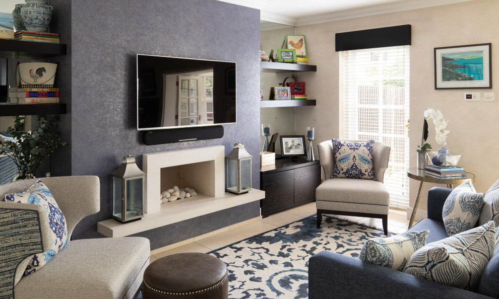 Modernes Wohnzimmer mit blauer Wandfarbe, Porzellan-Bodenfliesen, Kaminumrandung aus Stein, TV-Wand und Tapetenwänden in Surrey