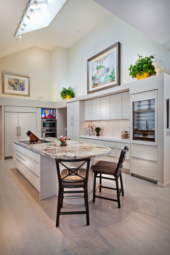 This is an example of an expansive contemporary galley kitchen in Minneapolis with flat-panel cabinets, light wood cabinets, white splashback, panelled appliances, a double-bowl sink, granite benchtops, porcelain splashback, porcelain floors and with island.