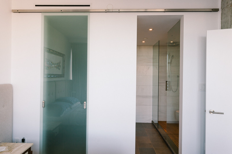 This is an example of a mid-sized modern bathroom in Vancouver with white walls, an alcove shower, slate floors, brown floor and an open shower.