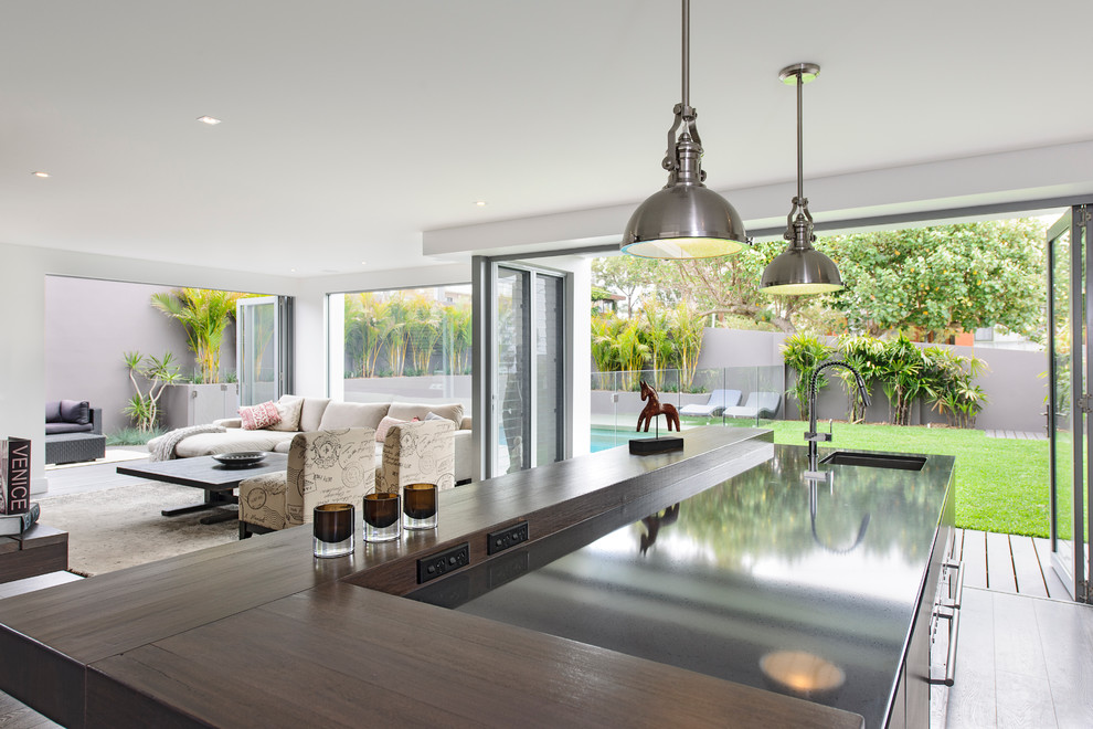 This is an example of a contemporary open plan kitchen in Sydney with an undermount sink and quartz benchtops.