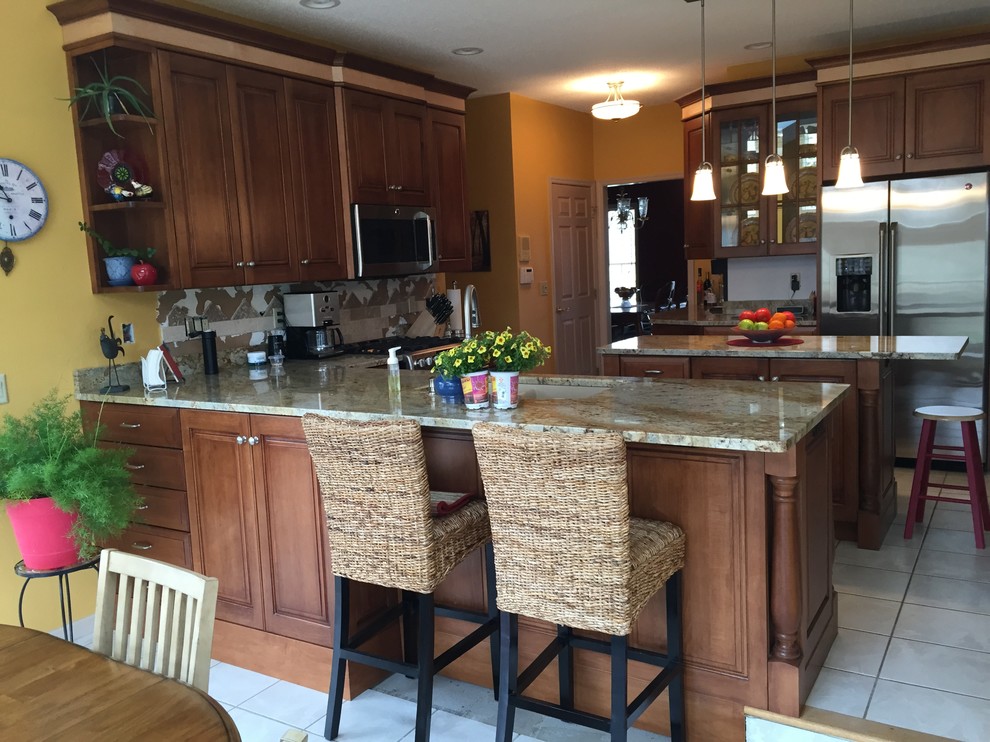 Inspiration for a mid-sized transitional l-shaped ceramic tile eat-in kitchen remodel in Cedar Rapids with medium tone wood cabinets, stainless steel appliances and two islands