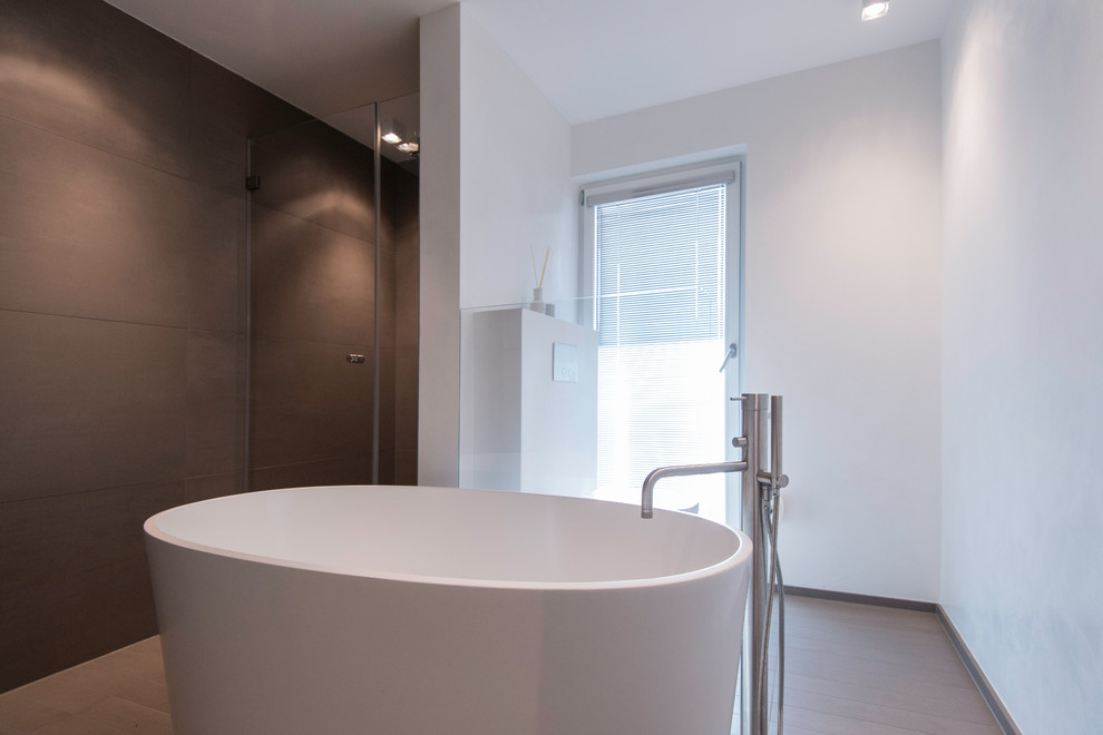 Modernes Badezimmer mit Trogwaschbecken, freistehender Badewanne, bodengleicher Dusche, Wandtoilette, braunen Fliesen, Keramikfliesen, weißer Wandfarbe und Keramikboden in Frankfurt am Main