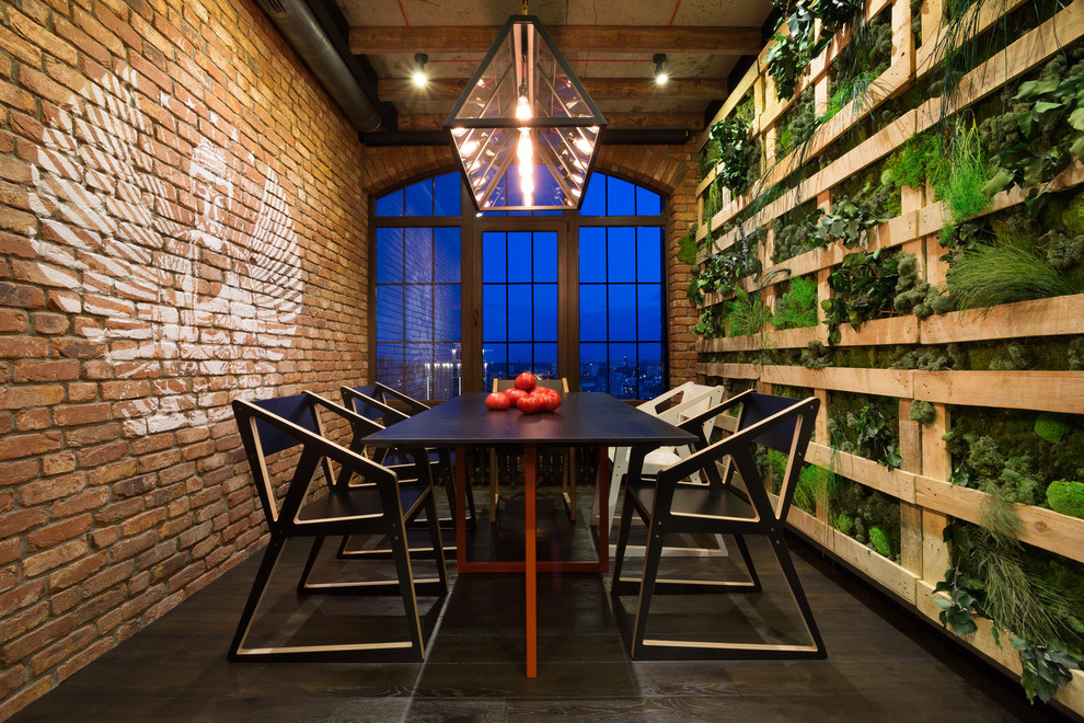 This is an example of an industrial dining room in Other with dark hardwood floors.