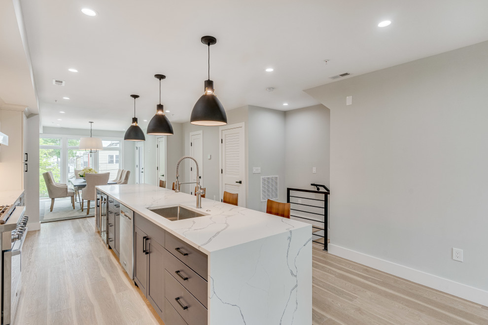 Design ideas for a mid-sized transitional single-wall eat-in kitchen in DC Metro with an undermount sink, flat-panel cabinets, quartz benchtops, engineered quartz splashback, stainless steel appliances and with island.