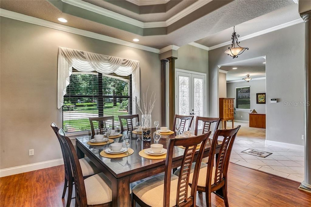 Design ideas for a mid-sized traditional open plan dining in Orlando with dark hardwood floors and recessed.