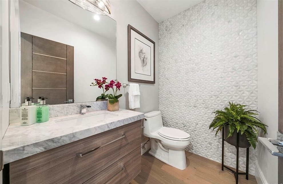Inspiration for a mid-sized contemporary powder room in Orange County with flat-panel cabinets, brown cabinets, white tile, mosaic tile, marble benchtops and white benchtops.