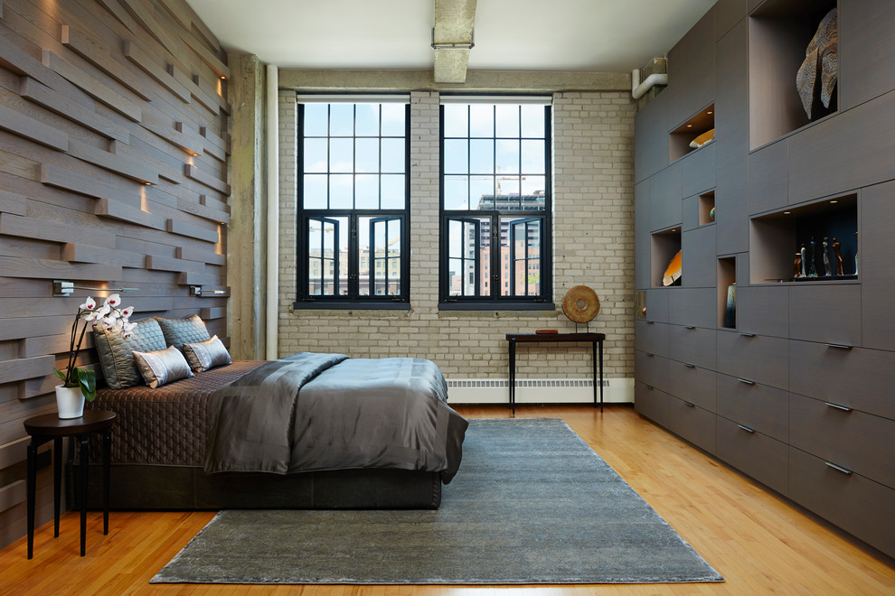 Design ideas for an industrial master bedroom in Minneapolis with brown walls, medium hardwood floors and no fireplace.