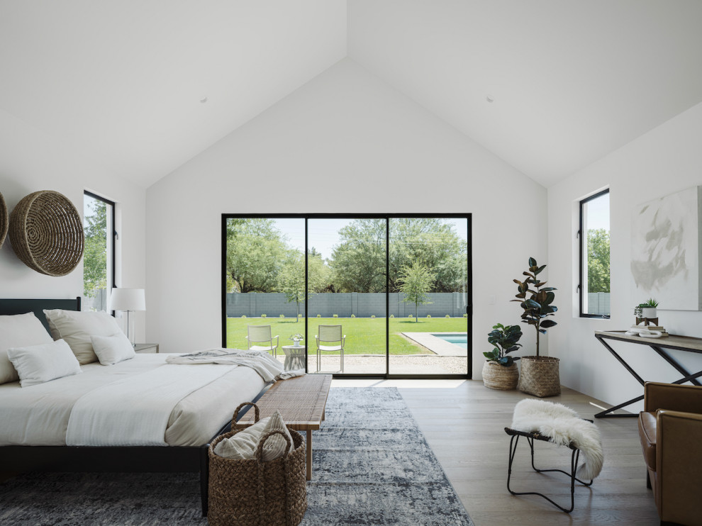 Inspiration for a scandi master bedroom in Phoenix with white walls, light hardwood flooring and a vaulted ceiling.
