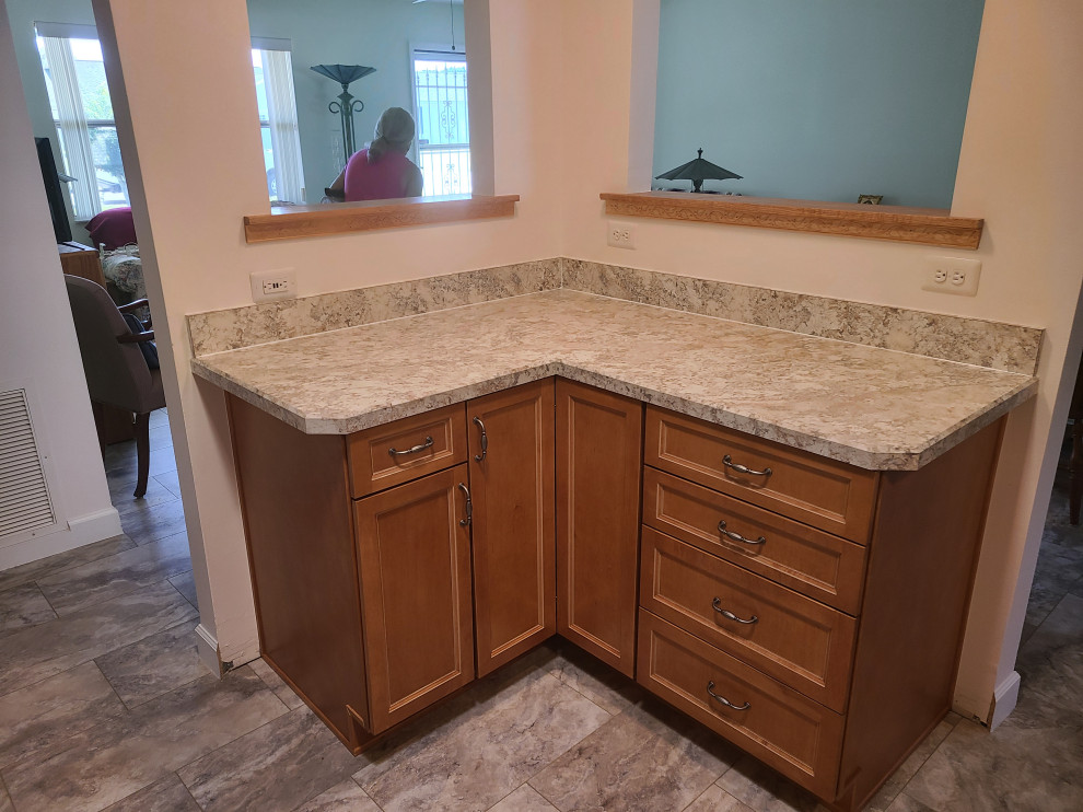 Eat-in kitchen - mid-sized l-shaped eat-in kitchen idea with flat-panel cabinets, medium tone wood cabinets, laminate countertops, an island and white countertops