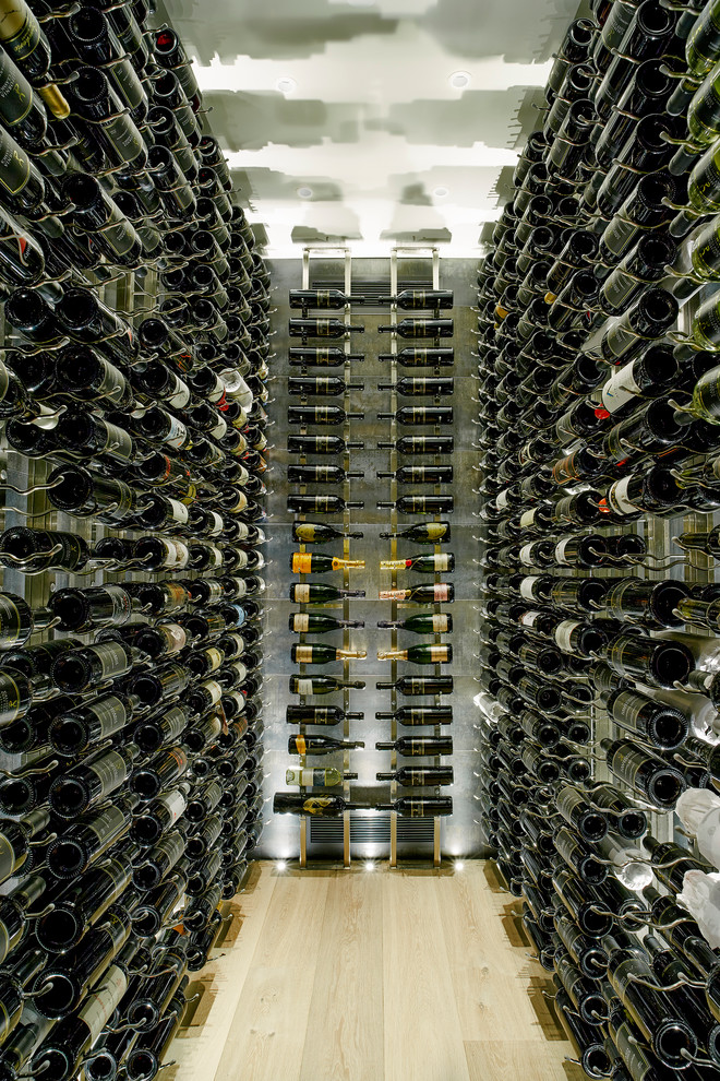 Mid-sized contemporary wine cellar in Vancouver with light hardwood floors and display racks.