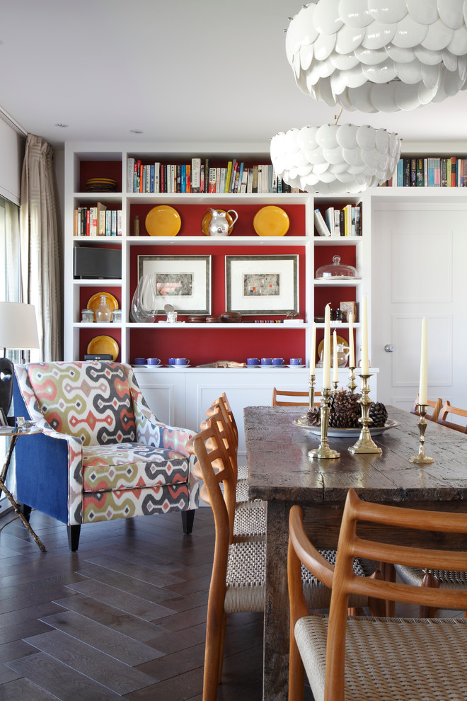 Contemporary dining room in London with red walls and dark hardwood floors.
