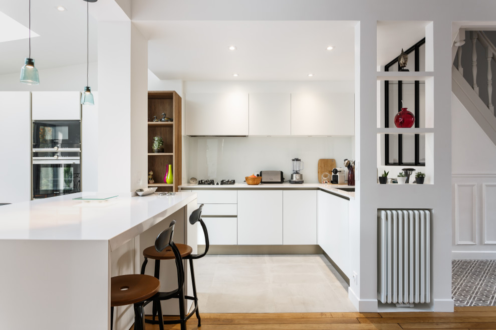 Design ideas for a large contemporary l-shaped open plan kitchen in Paris with flat-panel cabinets, white cabinets, white splashback, panelled appliances, with island, white benchtop, an undermount sink, quartzite benchtops, glass sheet splashback, ceramic floors, grey floor and recessed.