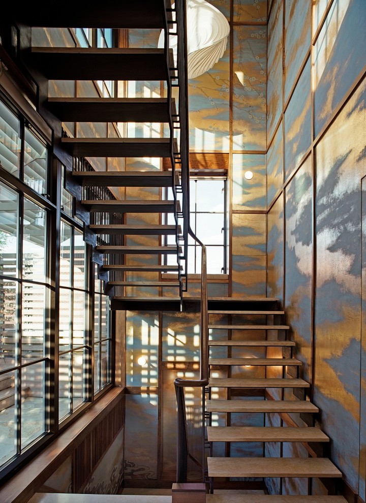 This is an example of a contemporary wood u-shaped staircase in New York with open risers.