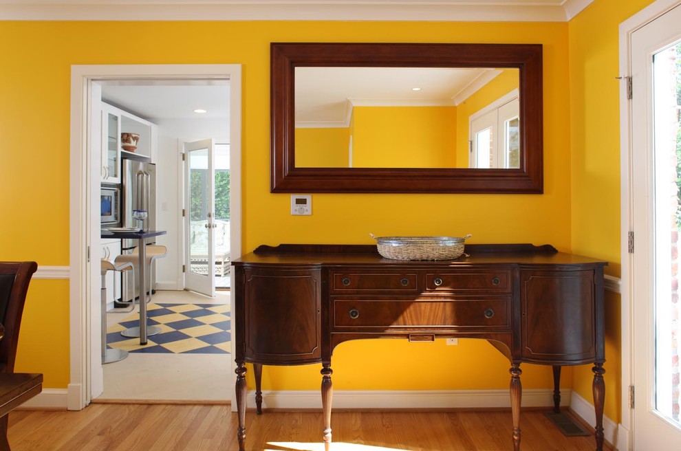 Inspiration for an eclectic dining room in DC Metro with yellow walls and medium hardwood floors.