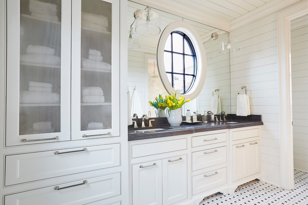 This is an example of a beach style bathroom in Other with recessed-panel cabinets, white cabinets, white walls, mosaic tile floors, an undermount sink, white floor and grey benchtops.