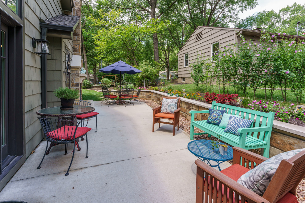 Foto de patio grande en patio trasero con chimenea y losas de hormigón