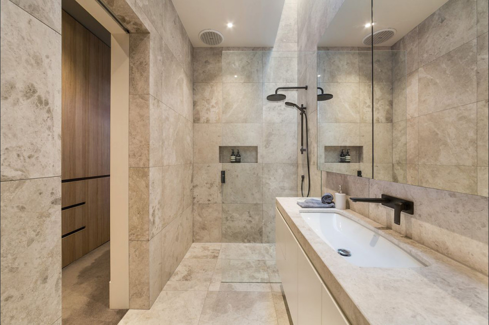 Inspiration for a large contemporary master bathroom in Melbourne with flat-panel cabinets, white cabinets, an open shower, beige tile, beige walls, a trough sink, beige floor, an open shower and beige benchtops.