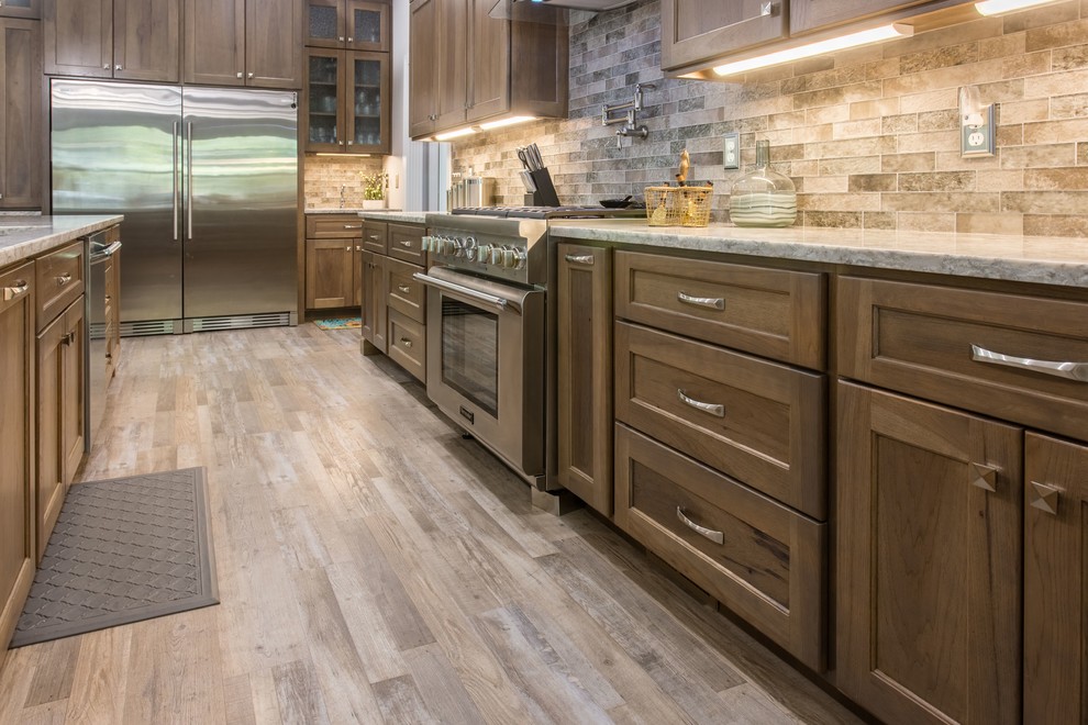 Transitional l-shaped open concept kitchen photo with shaker cabinets, stainless steel appliances and an island