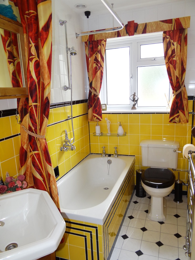 Inspiration for a small midcentury kids bathroom in Hampshire with a drop-in tub, a shower/bathtub combo, a one-piece toilet, yellow tile, ceramic tile, vinyl floors and a pedestal sink.