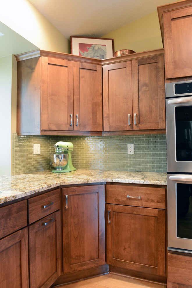 Inspiration for a mid-sized transitional u-shaped light wood floor open concept kitchen remodel with an undermount sink, shaker cabinets, medium tone wood cabinets, granite countertops, glass tile backsplash, stainless steel appliances and an island
